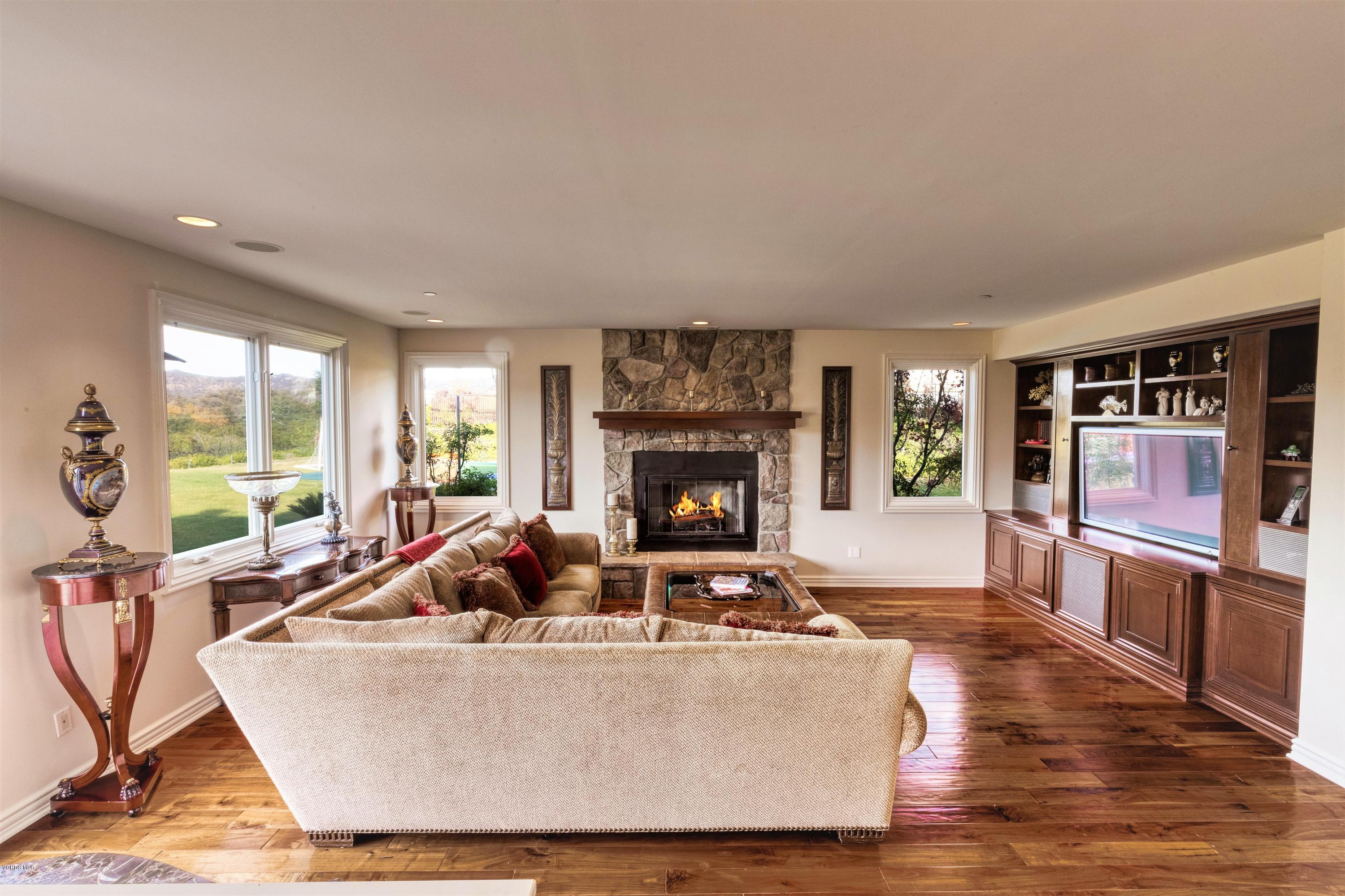 25741 Piuma Road Calabasas, CA 91302 - Photo 14 of 38 a living room with fireplace furniture and a large window