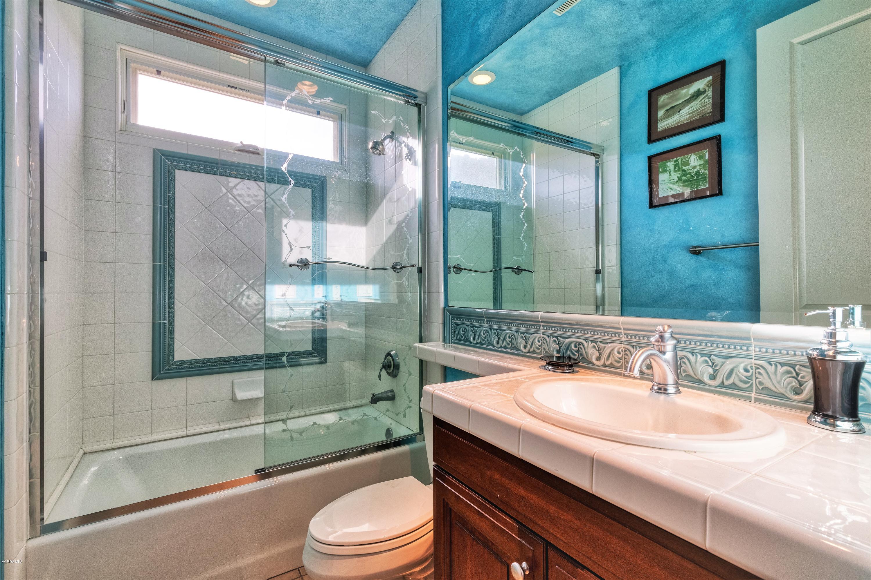 25741 Piuma Road Calabasas, CA 91302 - Photo 26 of 38 a bathroom with a granite countertop sink a toilet a mirror and shower