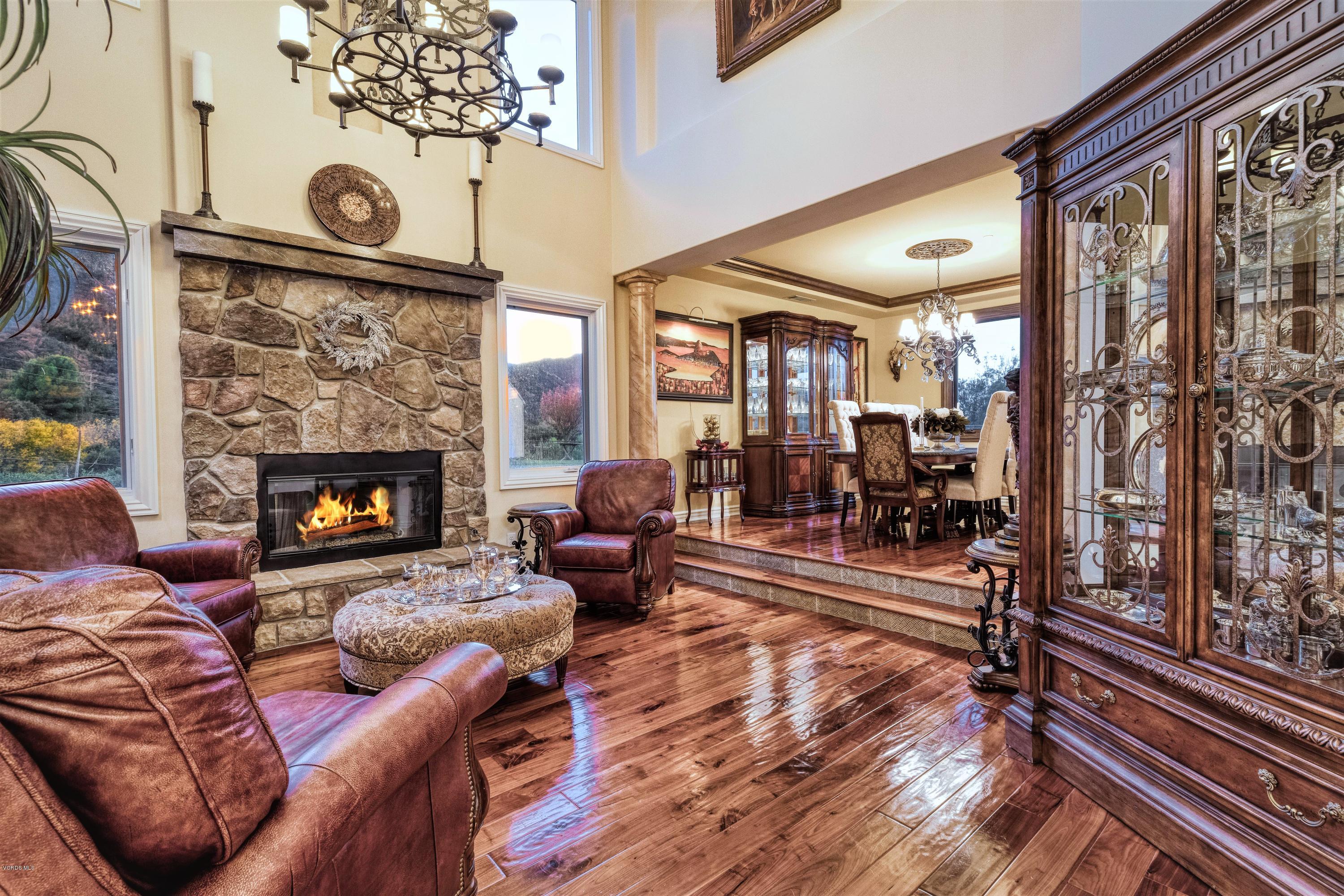 25741 Piuma Road Calabasas, CA 91302 - Photo 6 of 38 a living room with furniture a fireplace and a floor to ceiling window