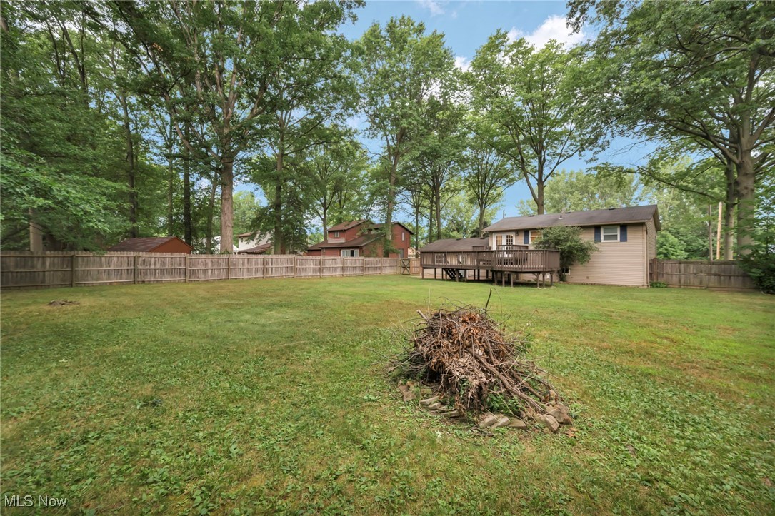 47655 Cooper Foster Park Road Amherst, OH 44001 - Photo 46 of 49 Fenced backyard featuring a wooden deck and view of scattered trees