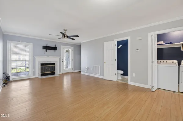 an empty room with a fireplace and wooden floor