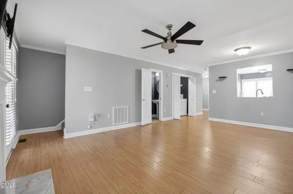 a view of empty room with wooden floor and window