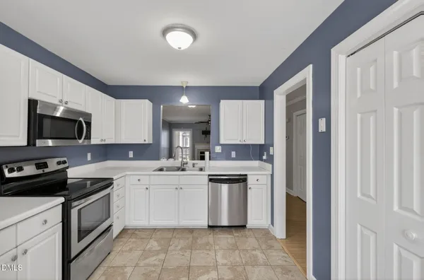 a kitchen with a sink stove top oven and cabinets