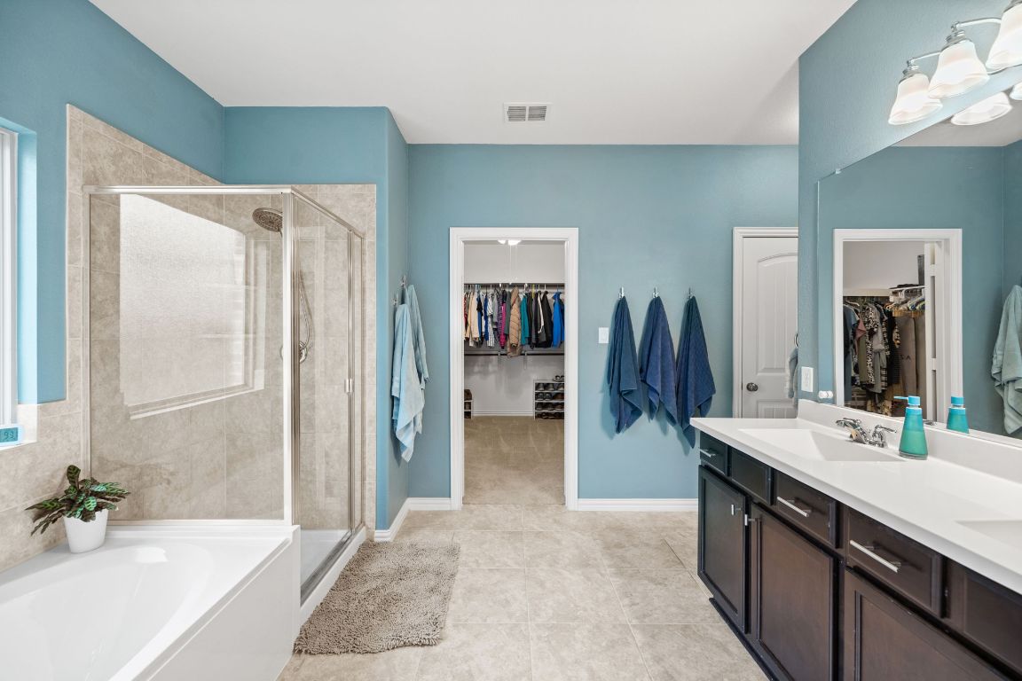 454 Shale Circle Buda, TX 78610 - Photo 11 of 27 a spacious bathroom with a double vanity sink and a mirror