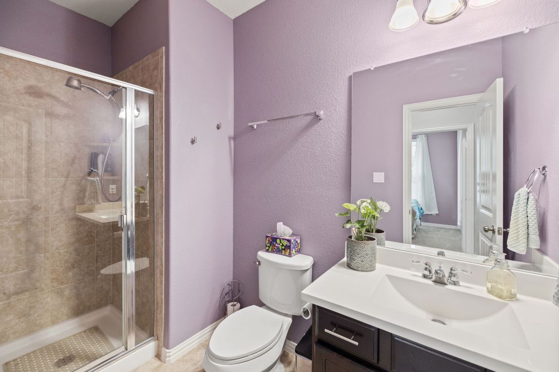 454 Shale Circle Buda, TX 78610 - Photo 13 of 27 a bathroom with a sink vanity mirror and toilet