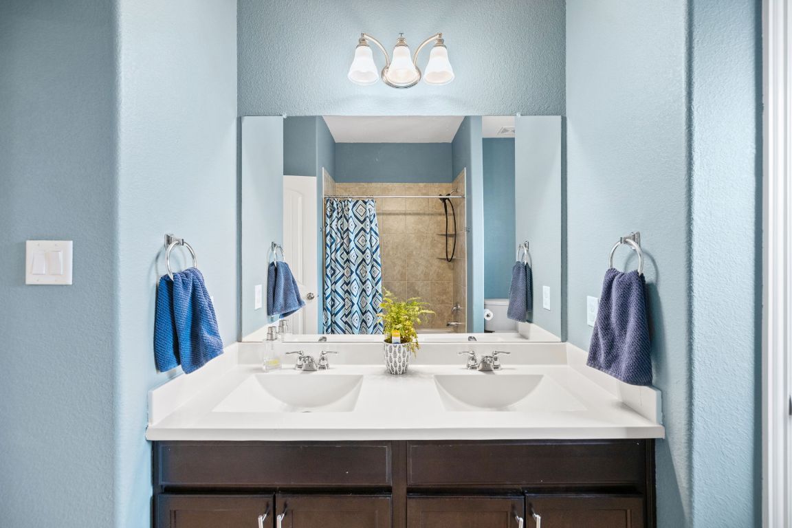 454 Shale Circle Buda, TX 78610 - Photo 17 of 27 a bathroom with a sink and a mirror