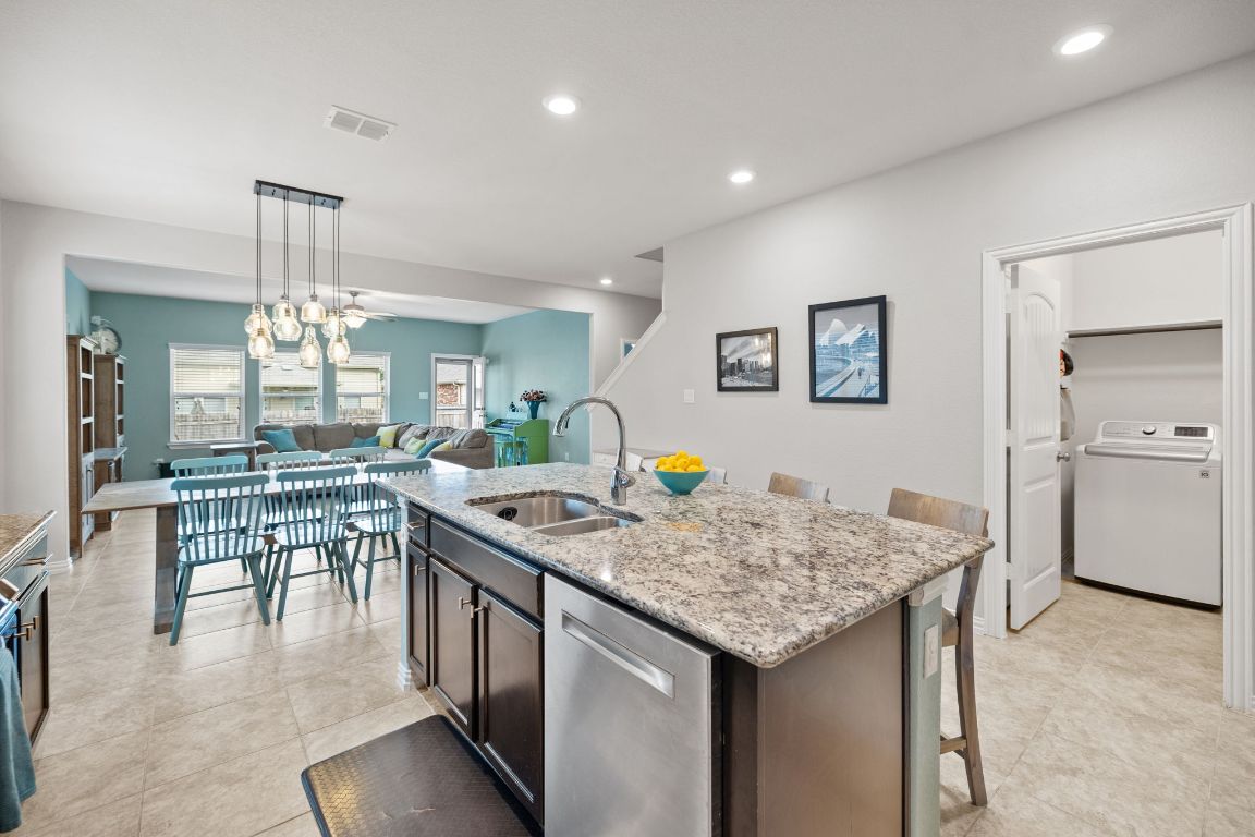 454 Shale Circle Buda, TX 78610 - Photo 2 of 27 a kitchen with a table chairs and wooden floor