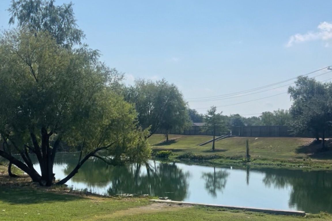 454 Shale Circle Buda, TX 78610 - Photo 26 of 27 a view of a lake with houses in the back