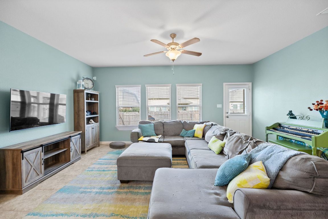 454 Shale Circle Buda, TX 78610 - Photo 7 of 27 a living room with furniture a flat screen tv and a fireplace