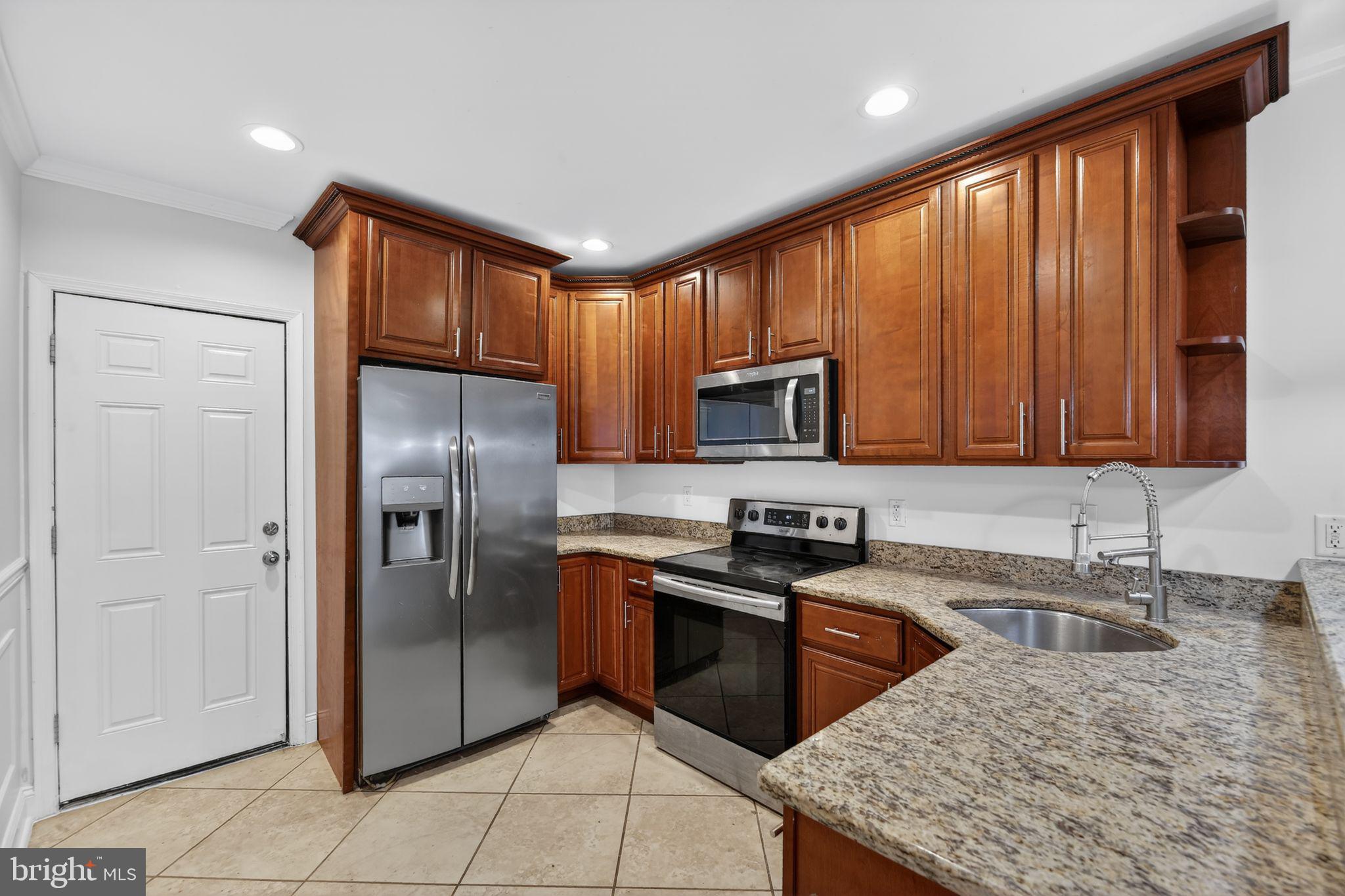 2413 North Carlisle Street Philadelphia, PA 19132 - Photo 16 of 30 a kitchen with stainless steel appliances granite countertop a refrigerator a stove a sink and a microwave