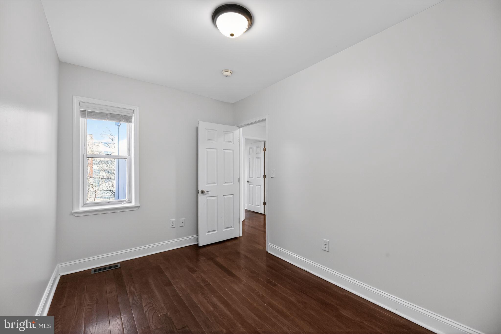 2413 North Carlisle Street Philadelphia, PA 19132 - Photo 17 of 30 an empty room with wooden floor and windows