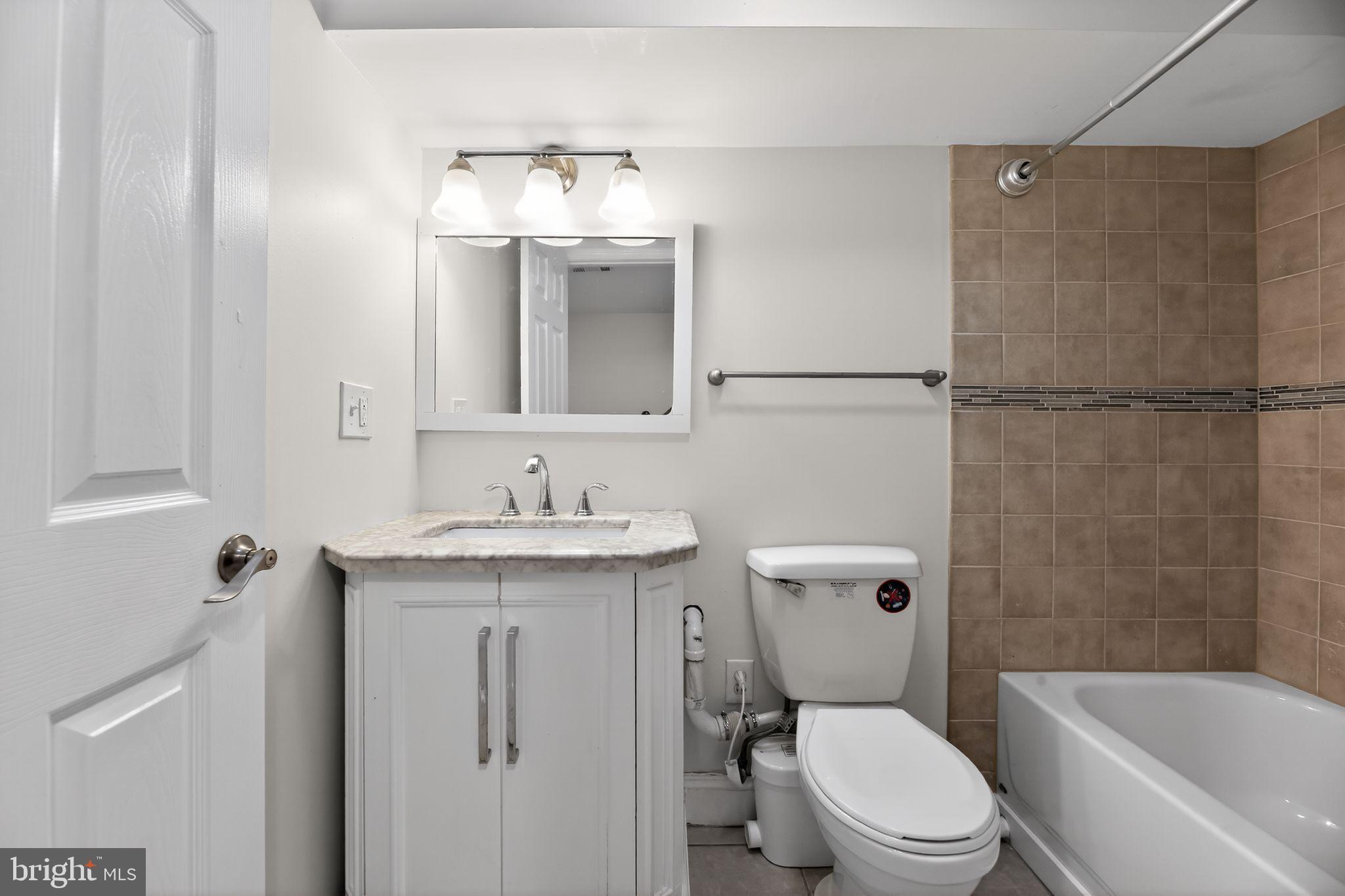 2413 North Carlisle Street Philadelphia, PA 19132 - Photo 20 of 30 a bathroom with a granite countertop toilet sink and mirror