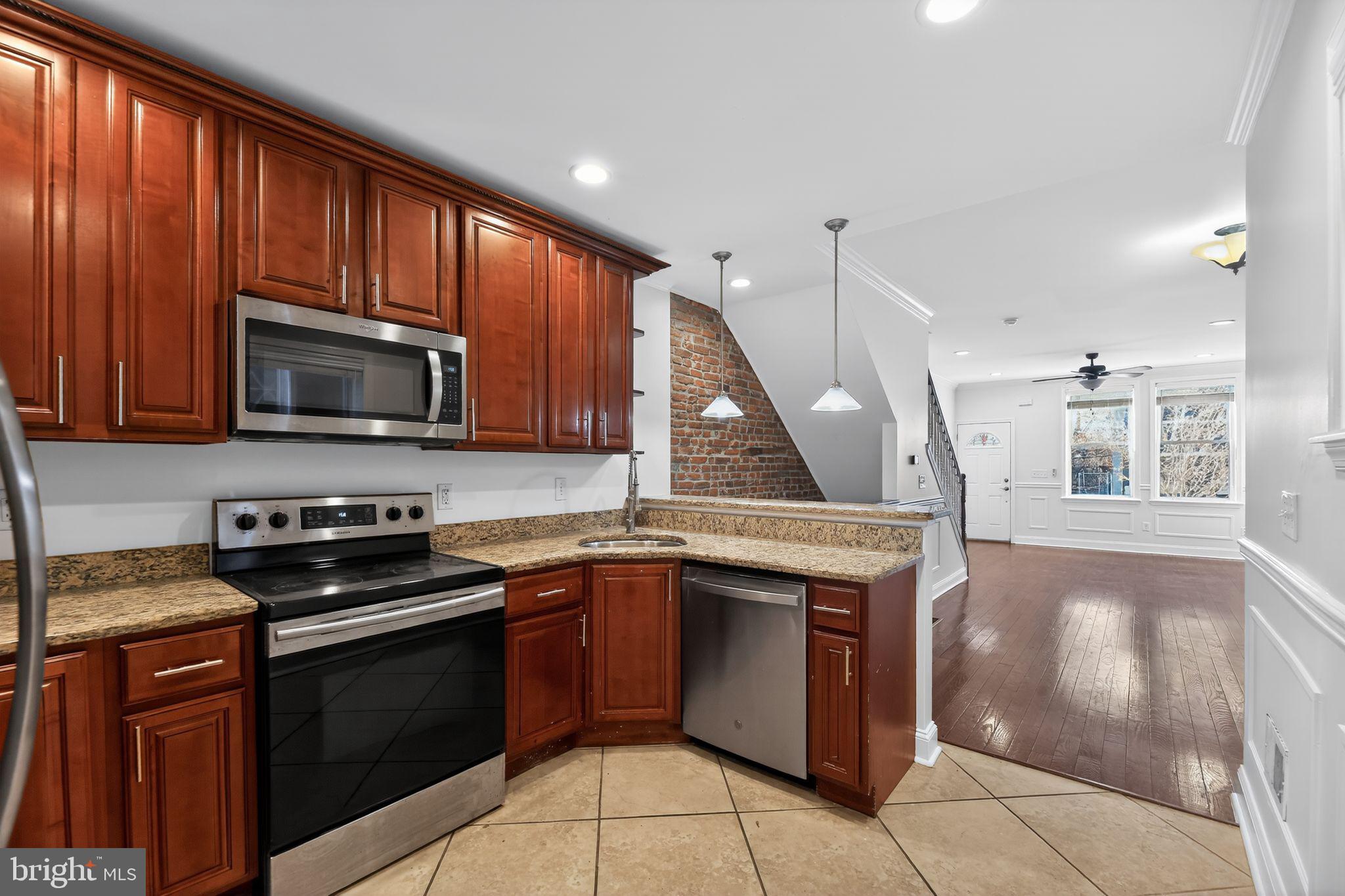 2413 North Carlisle Street Philadelphia, PA 19132 - Photo 6 of 30 a kitchen with a stove sink and microwave