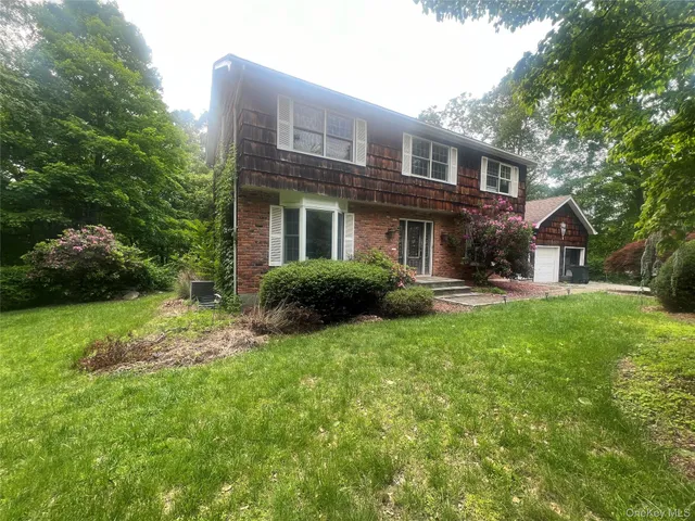 a front view of a house with yard and green space