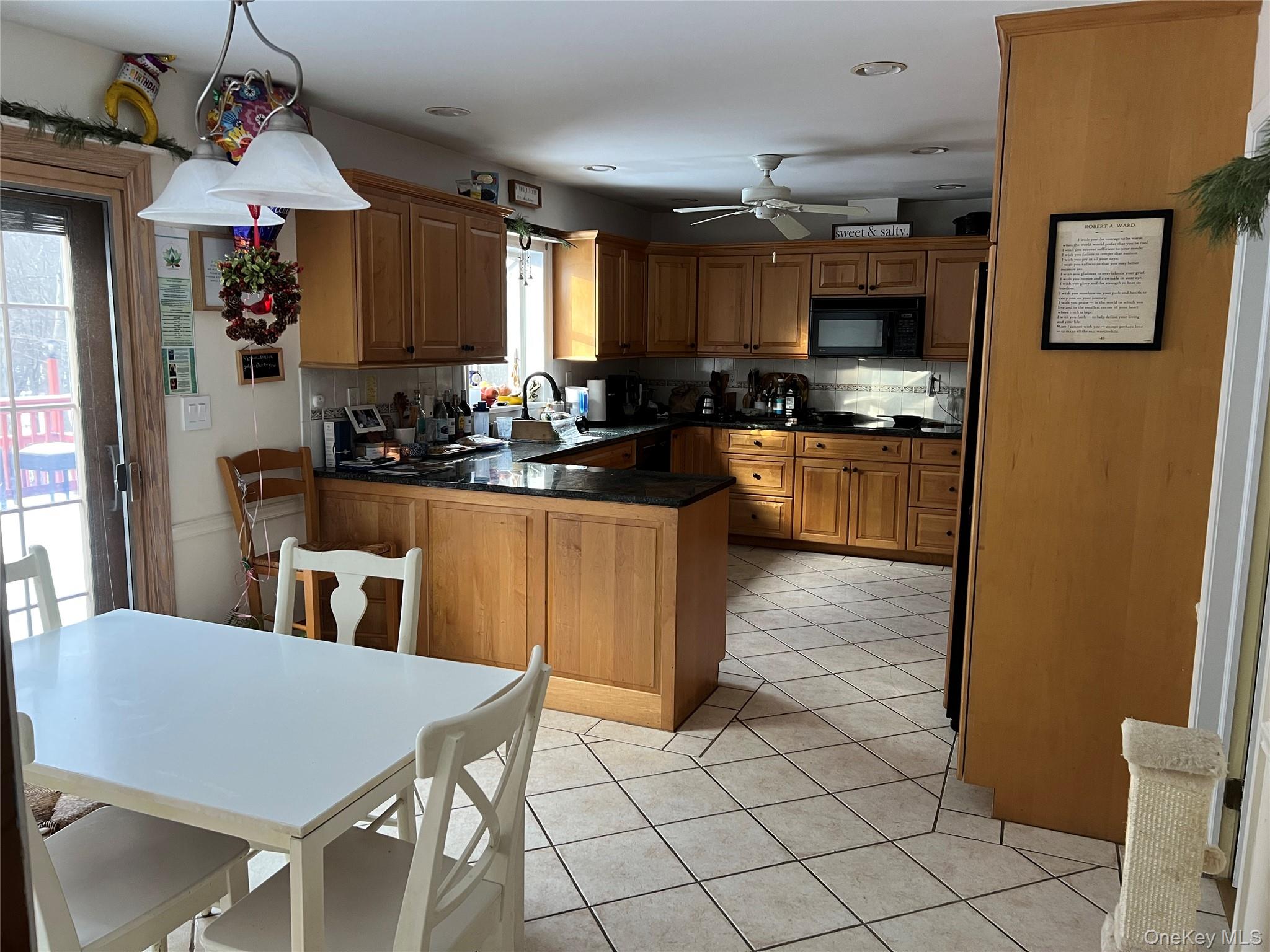 17 Birch Hill Road Putnam Valley, NY 10579 - Photo 6 of 24 a kitchen with stainless steel appliances a dining table chairs and granite counter tops