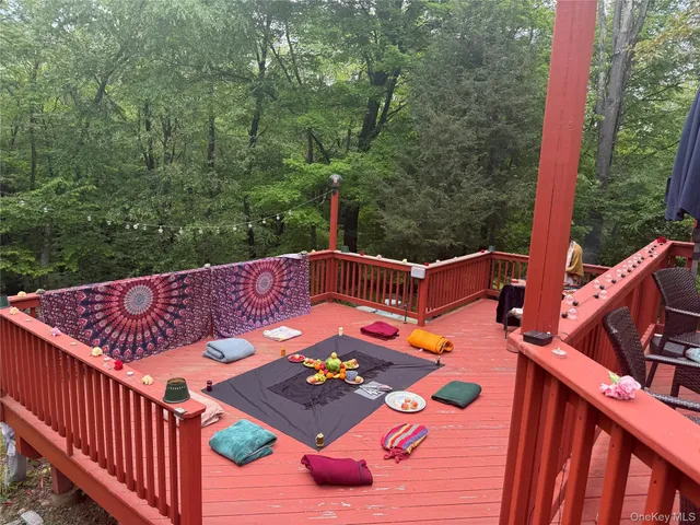 a view of a roof deck with table and chairs a barbeque with wooden floor and fence