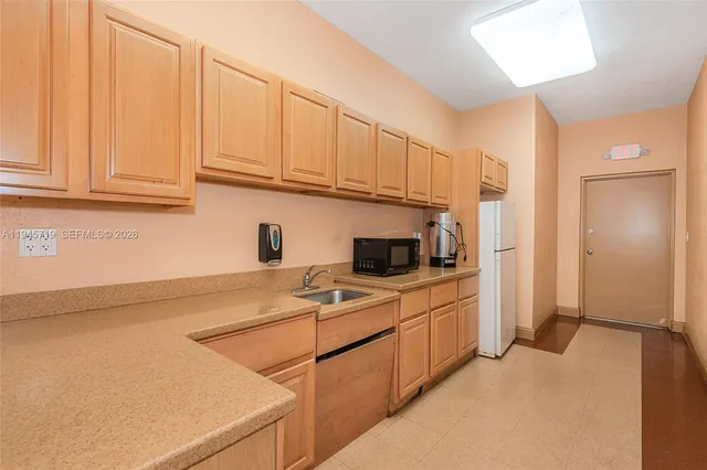 a kitchen with stainless steel appliances granite countertop a sink refrigerator and cabinets
