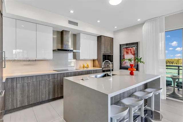 a kitchen with kitchen island a stove a table and chairs in it