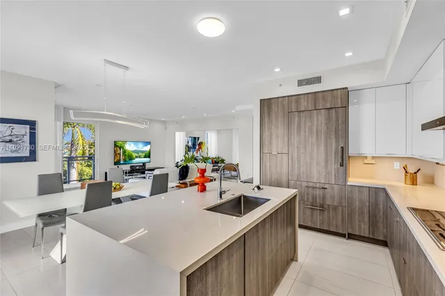 a kitchen that has a lot of cabinets a sink and appliances in it