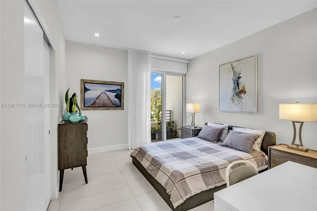 a bedroom with bed and a painting on the wall