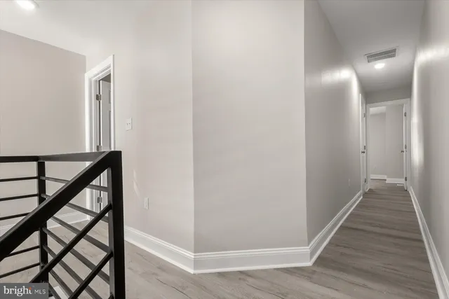 a view of a hallway with wooden floor and staircase