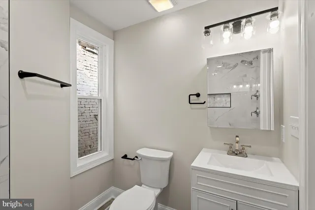 a bathroom with a sink a mirror and a toilet