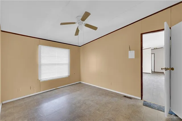 an empty room with a window and a ceiling fan