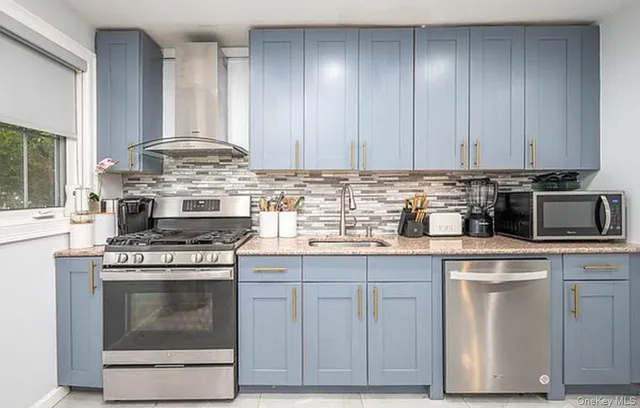 a kitchen with granite countertop a stove sink and cabinets