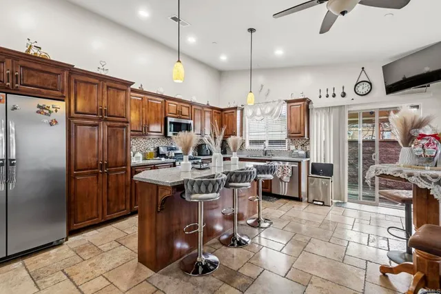 a kitchen with kitchen island granite countertop a sink appliances and cabinets