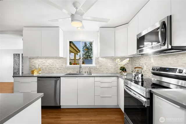 a kitchen with granite countertop a sink a stove and cabinets