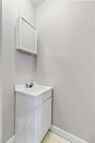 a utility room with a sink a vanity and mirror