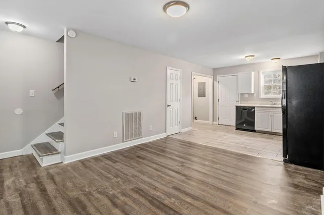 a view of empty room with wooden floor and window