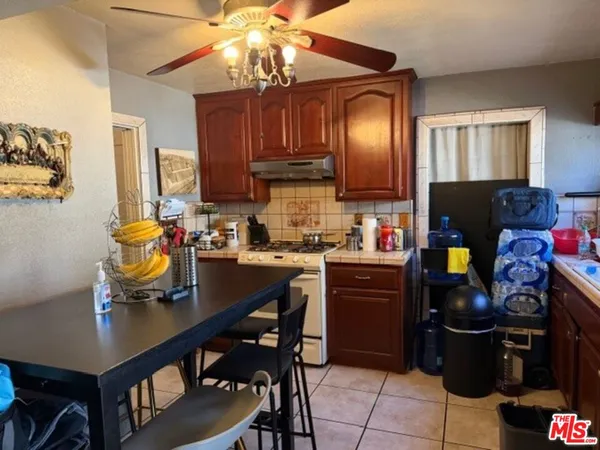 a kitchen with stainless steel appliances granite countertop a refrigerator a stove top oven a sink dishwasher and dining table with wooden floor