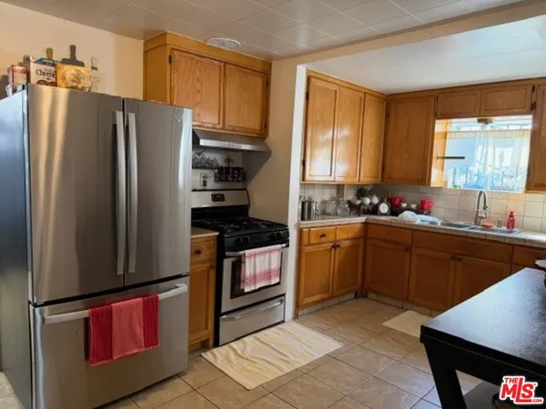a kitchen with stainless steel appliances granite countertop a refrigerator stove top oven and sink
