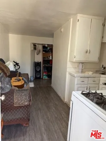 a kitchen with stainless steel appliances granite countertop a refrigerator a stove and a wooden floors