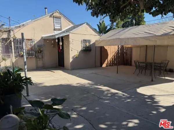 a view of a patio with table and chairs potted plants
