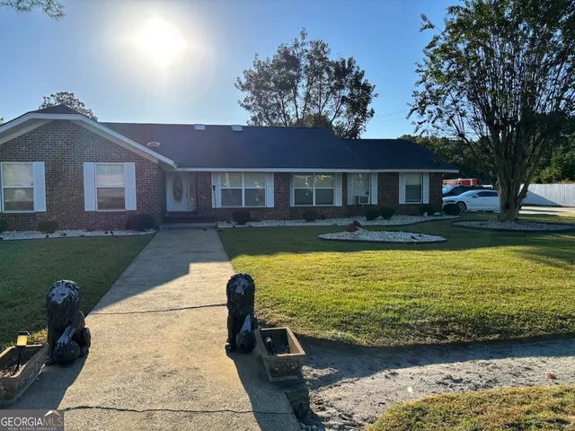a view of a house with pool plants and large trees