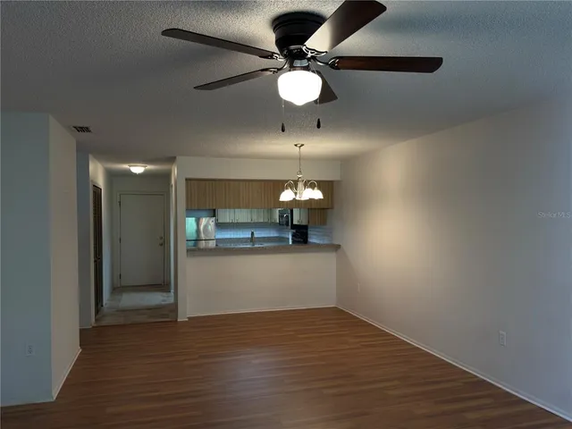 a view of a livingroom with a ceiling fan window and wooden floor