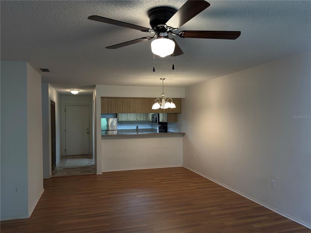 12155 Environmental Drive, Unit 6 New Port Richey, FL 34654 - Photo 13 of 31 a view of an empty room and kitchen with wooden floor