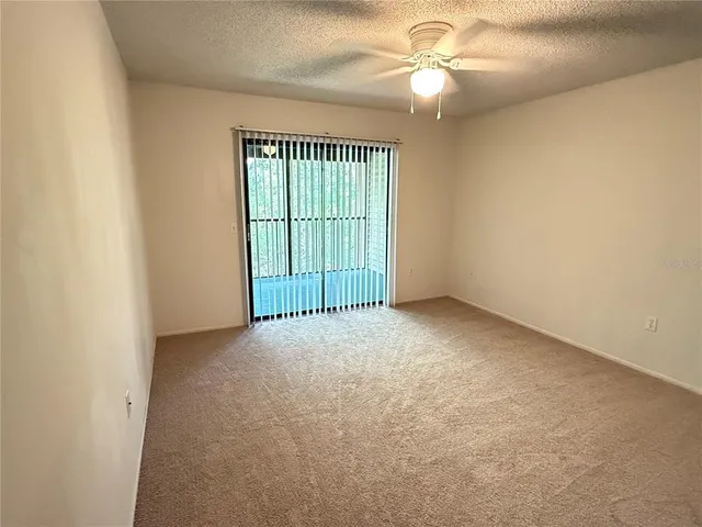 an empty room with closet and chandelier fan