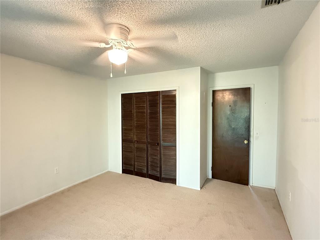 12155 Environmental Drive, Unit 6 New Port Richey, FL 34654 - Photo 16 of 31 an empty room with closet and chandelier fan