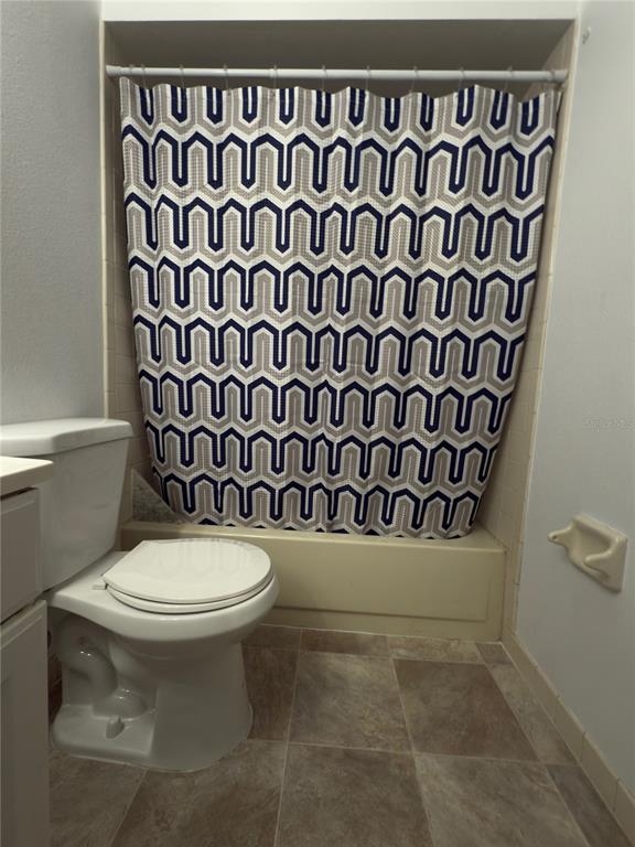 12155 Environmental Drive, Unit 6 New Port Richey, FL 34654 - Photo 22 of 31 a bathroom with a toilet and a shower curtain