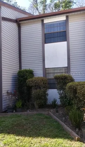 a front view of a house with garden and parking