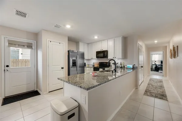 a kitchen with stainless steel appliances granite countertop a sink refrigerator and cabinets