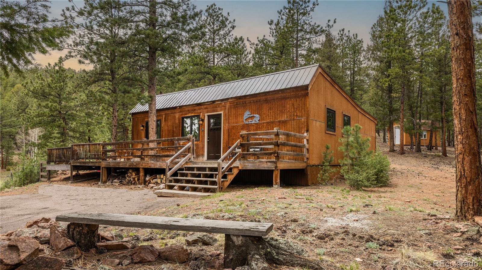 3763 County Road 43 Bailey, CO 80421 - Photo 3 of 40 a backyard of a house with barbeque oven table and chairs