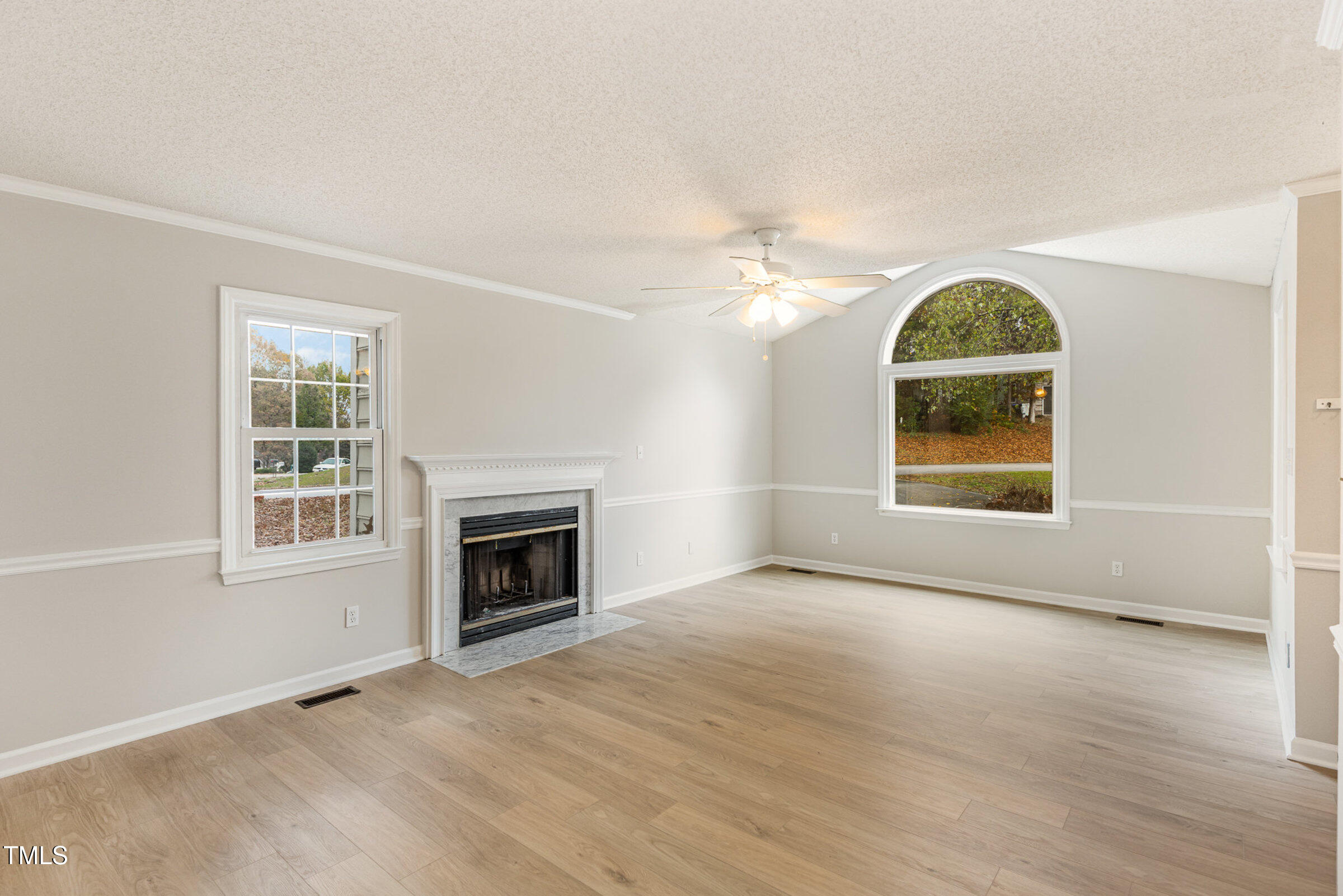 2117 Bufflehead Road Raleigh, NC 27616 - Photo 6 of 27 an empty room with windows fireplace and wooden floor