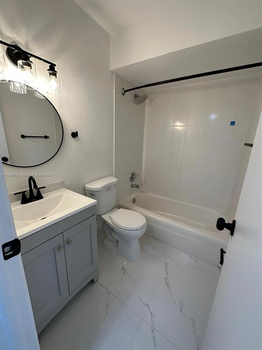 1740 Funston Street, Unit 12 Hollywood, FL 33020 - Photo 5 of 10 a bathroom with a toilet a sink and a mirror