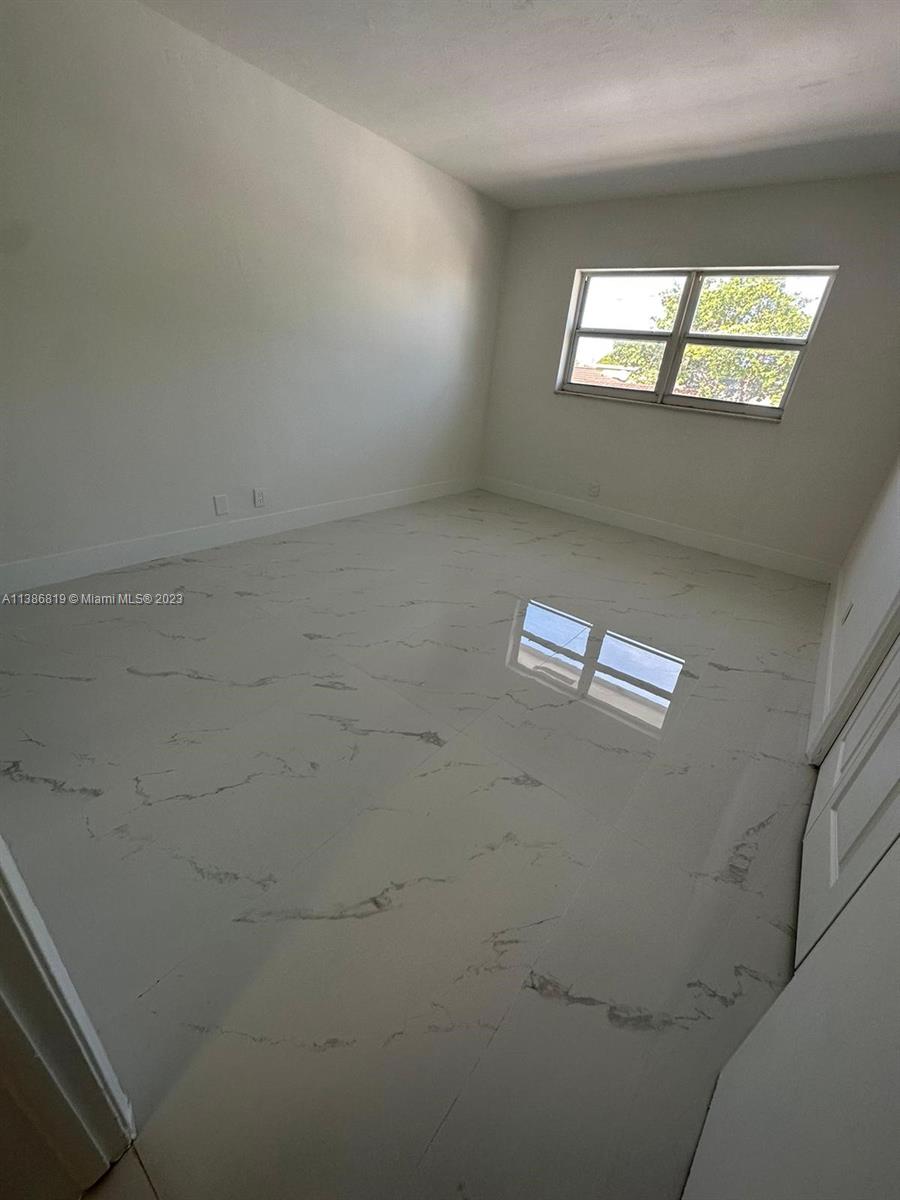 1740 Funston Street, Unit 12 Hollywood, FL 33020 - Photo 6 of 10 an empty room with windows and