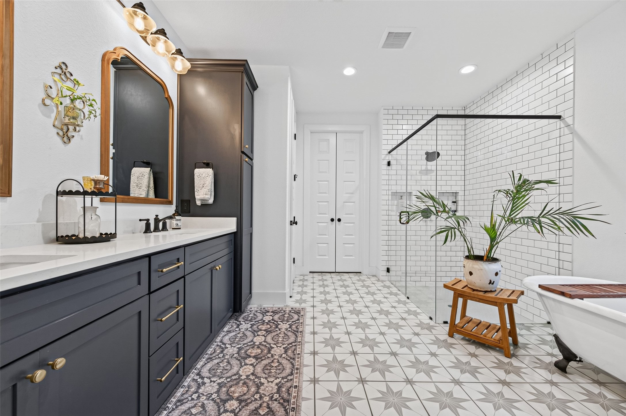 10915 Ruger Road Willis, TX 77378 - Photo 24 of 50 a spacious bathroom with a double vanity sink a large mirror a bathtub and a shower