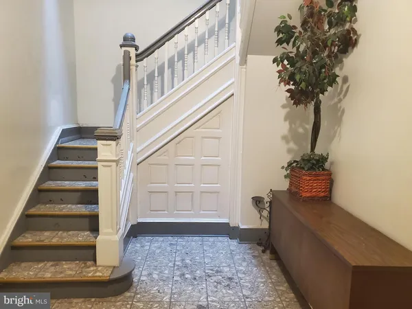 a view of staircase with white walls and a potted plant